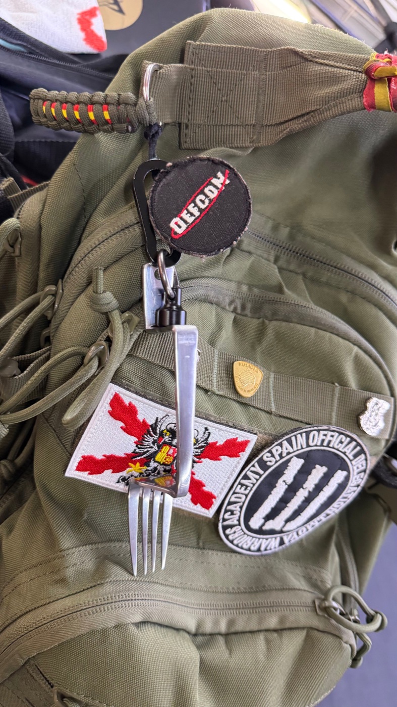 The FranckTheSolution Fork clipped by its carabiner to a tactical pack